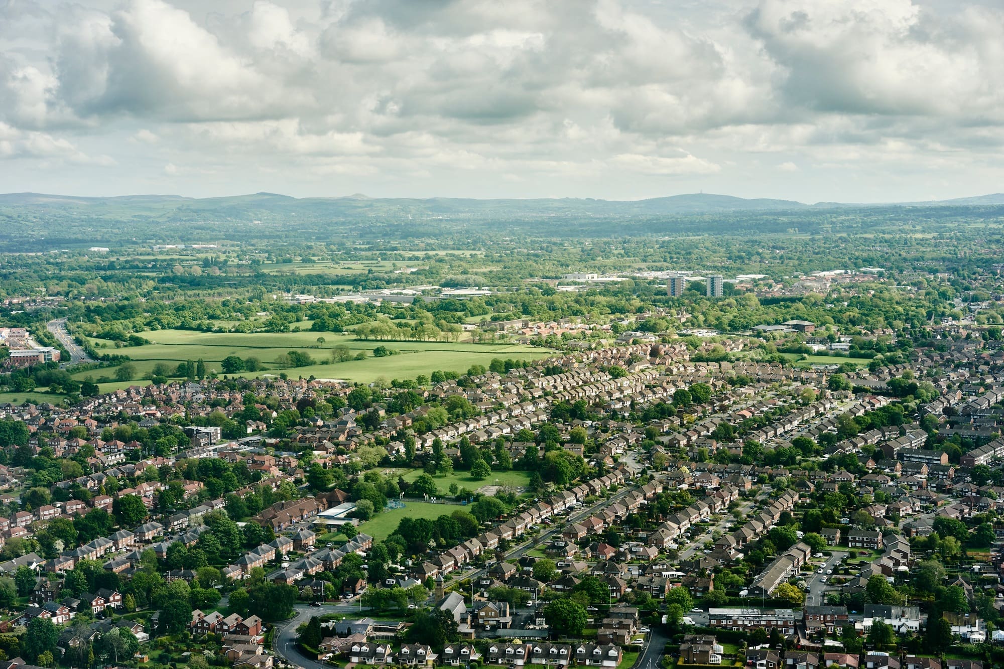Aerial view of suburban housing and distant landscape, England, UK